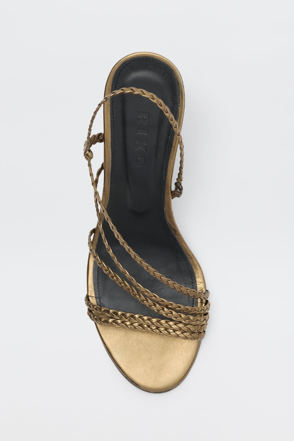 A top view of the Gracey - Gold sandal, featuring braided gold straps and a black insole with the RIXO brand name printed on it, set against a white background.