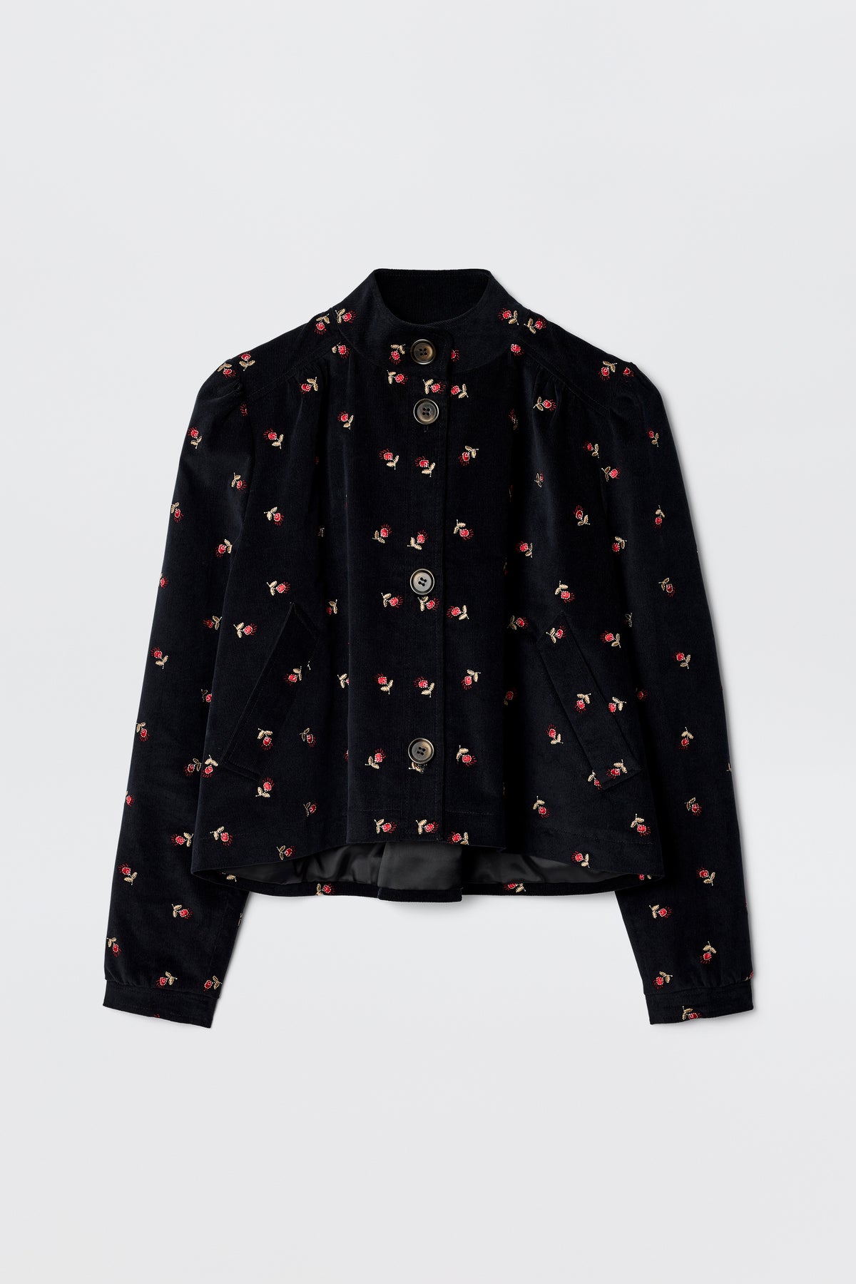 The Nyla - Dandy Embroidery Deep Navy is a 60s-inspired black velvet jacket with long sleeves, a mandarin collar, silver front buttons, and scattered pink and red floral embroidery.