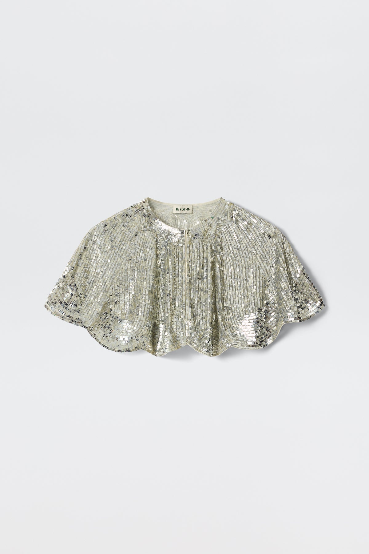 The Evienne - Art Deco Embellishment Pearl is a silver sequin capelet featuring a short, scalloped hem and gathered details, inspired by Art Deco capes, shown against a plain light background.