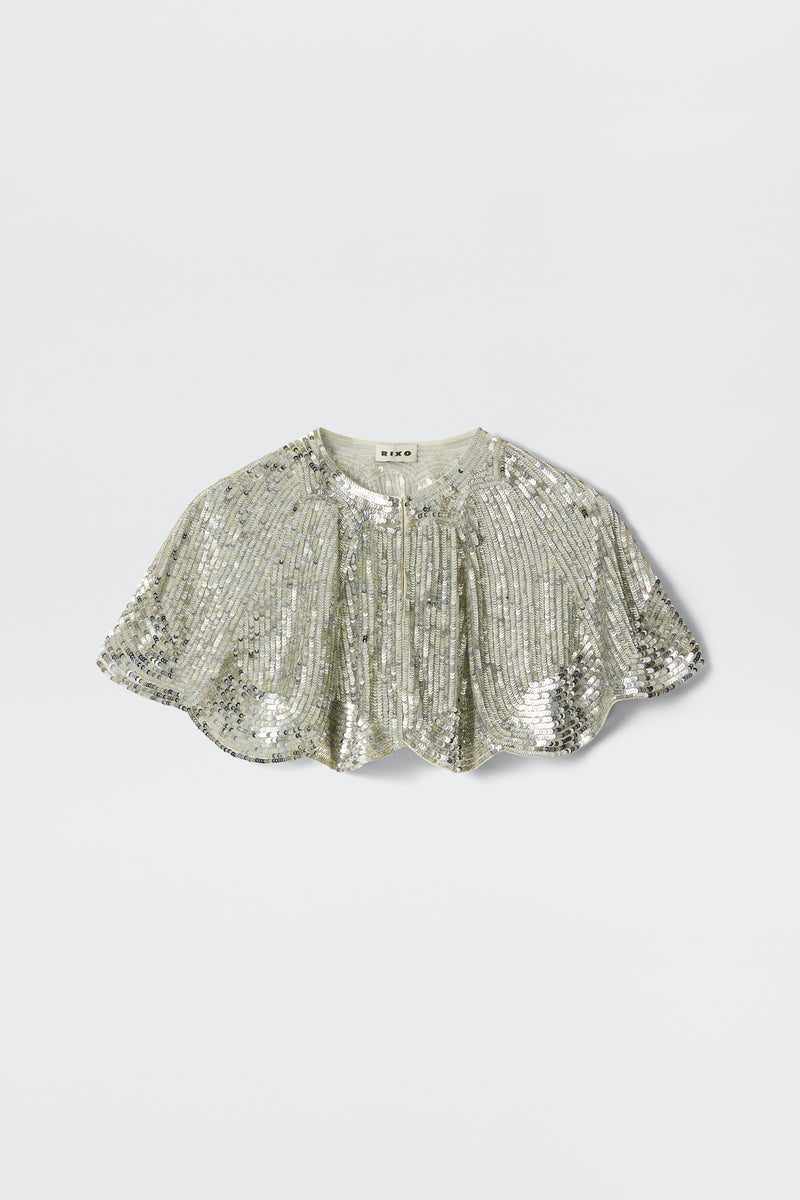 The Evienne - Art Deco Embellishment Pearl is a silver sequin capelet featuring a short, scalloped hem and gathered details, inspired by Art Deco capes, shown against a plain light background.