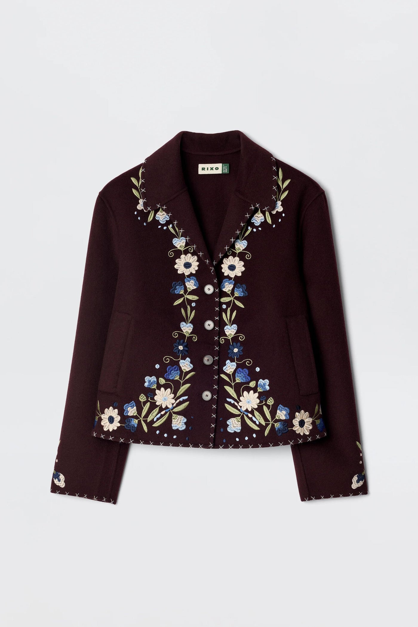 The Jude - Bliss Embroidery Brown jacket is a brown button-up with a collar, detailed with vibrant embroidery in white, blue, and green floral designs along the front, collar, and cuffs for a standout look.