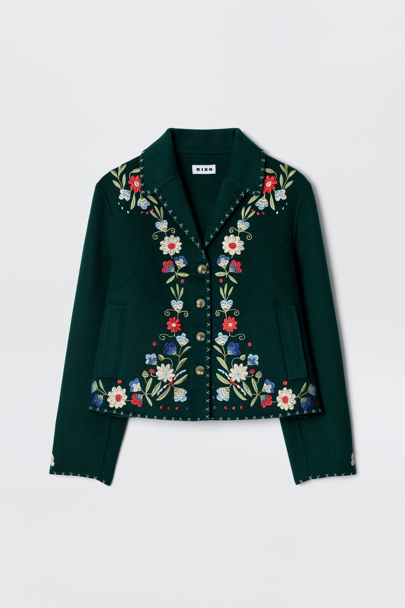 The Jude - Bliss Embroidery Green jacket by RIXO is a dark green, cropped piece with vibrant embroidery on the front, lapels, and cuffs, finished with decorative metallic buttons.