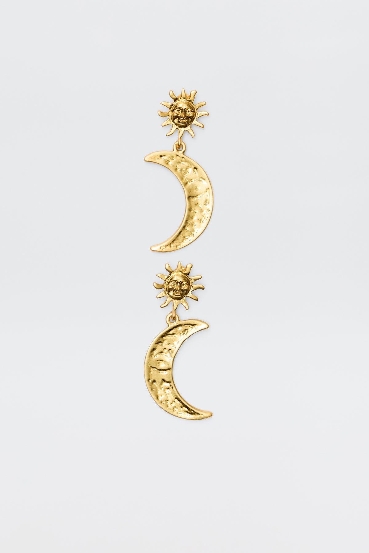 The Davies - Gold earrings feature gold-plated celestial charms: a textured crescent moon hangs from a detailed sun, creating a vintage-inspired look against a plain white background.