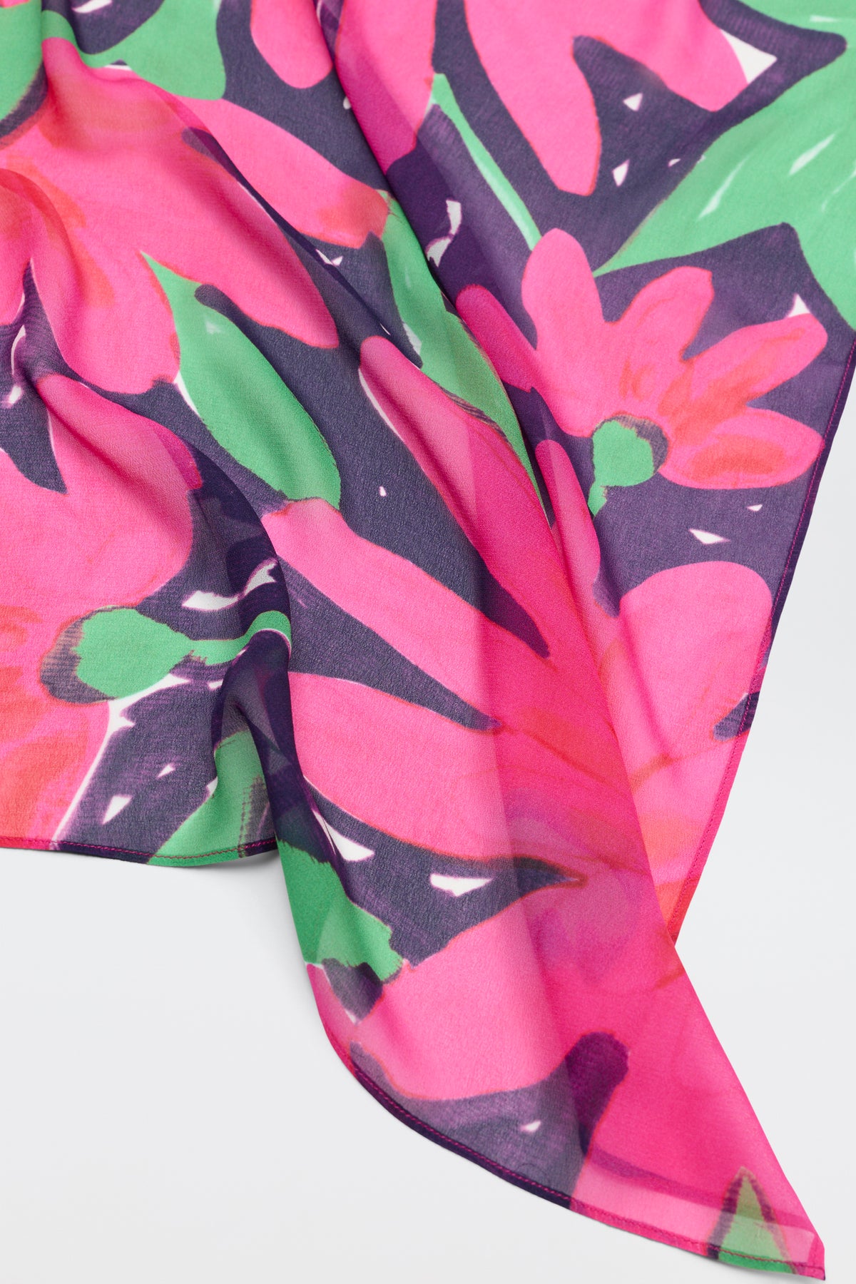 A close-up of Menno - Danish Floral, a lightweight, sheer fabric featuring a vibrant abstract floral pattern in pink, green, and purple on white.