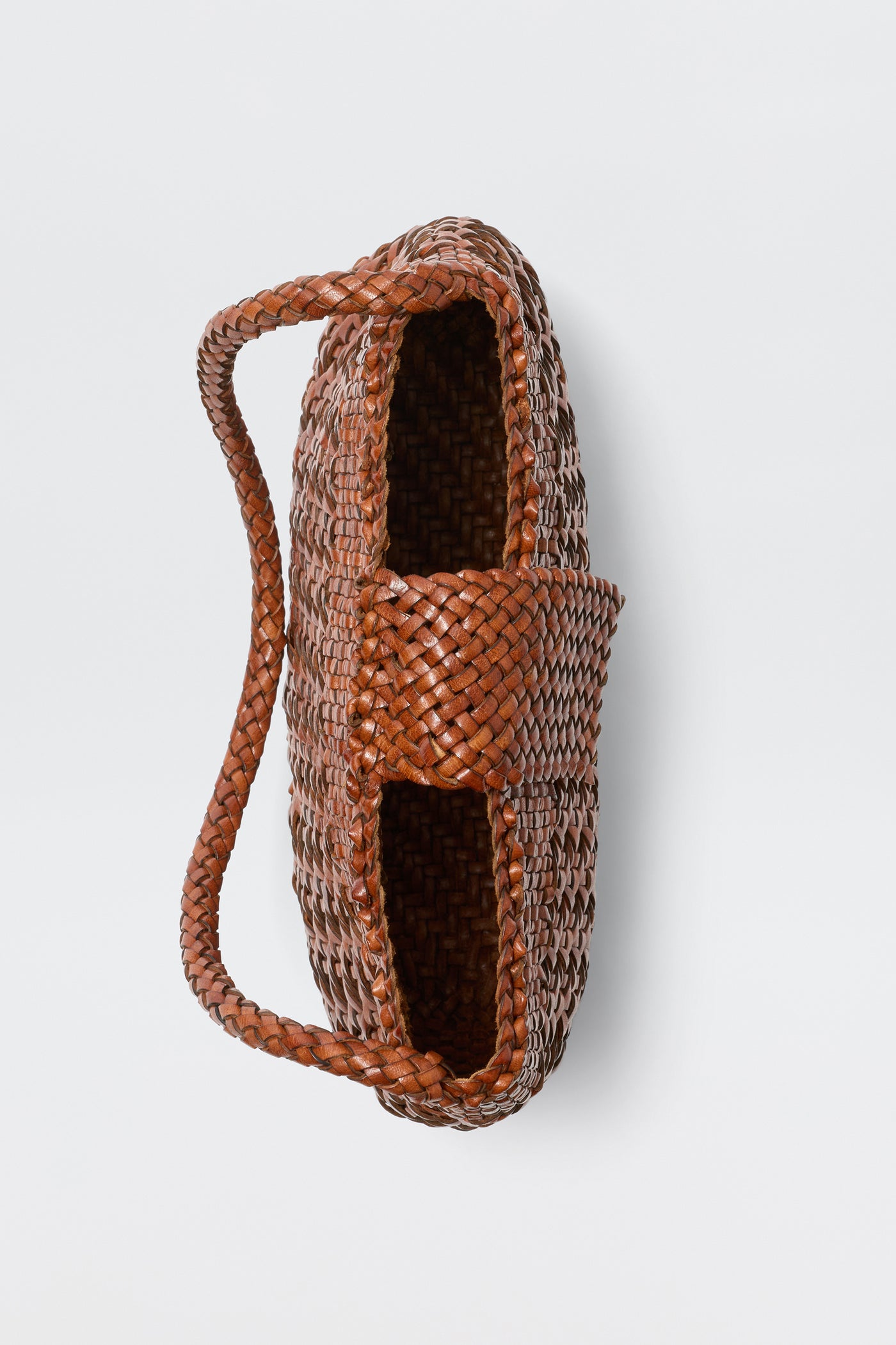 A top-down view of the Amoria - Tan basket, featuring a vintage-inspired woven design and a single thick handle made from the same material, set against a plain white background.