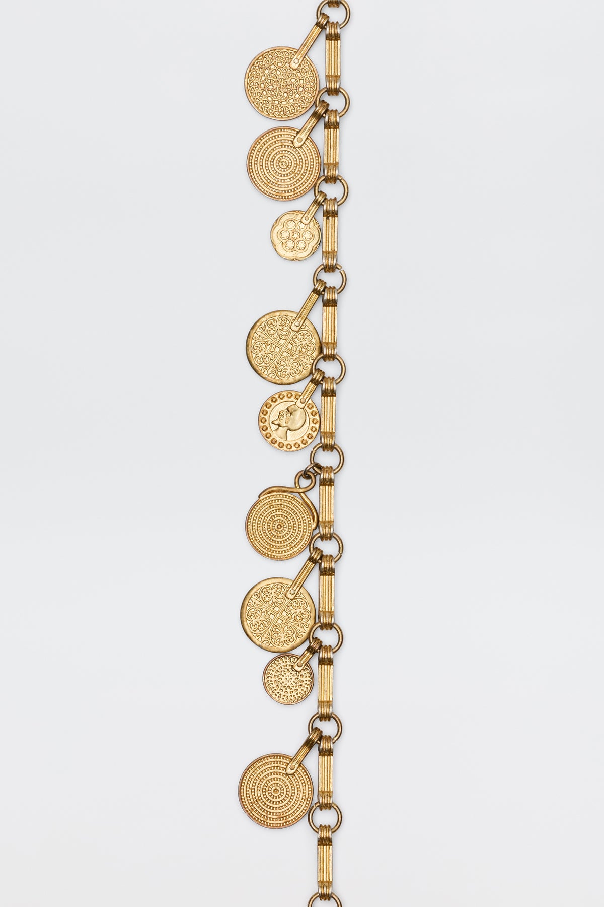 The Isolde - Gold bracelet features a gold-toned chain with multiple round, textured disc charms for a vintage-inspired look, shown against a plain white background.