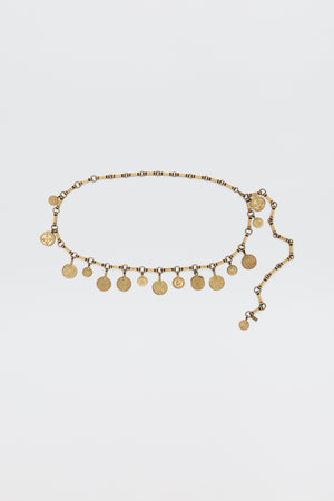 The Isolde - Gold belt features evenly spaced coin-shaped charms on a linked chain, bringing vintage glamour—ideal for pairing with RIXO dresses. Shown on a simple white background.