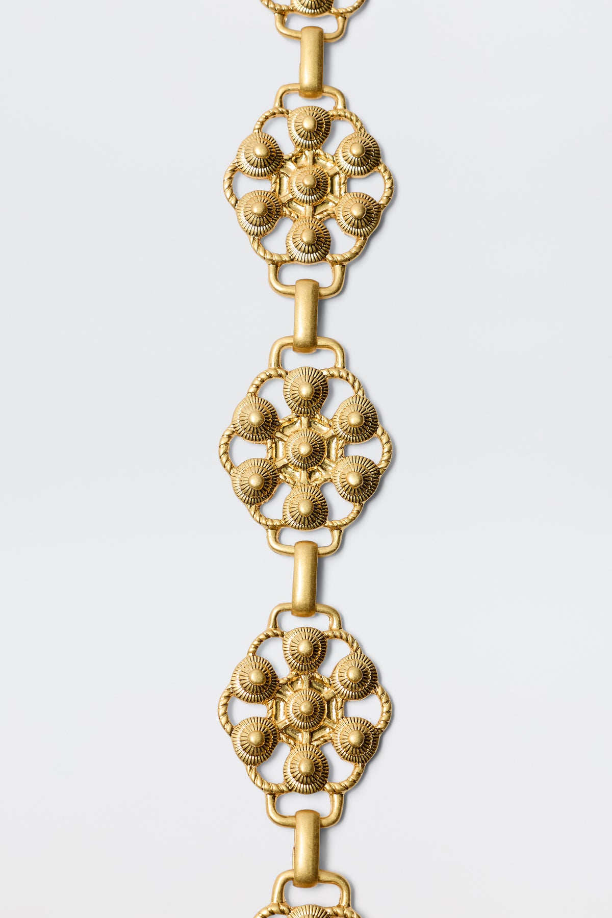 The Tiana - Gold bracelet features vintage-gold plating and a floral design inspired by RIXO’s signature daisy-chain belt.