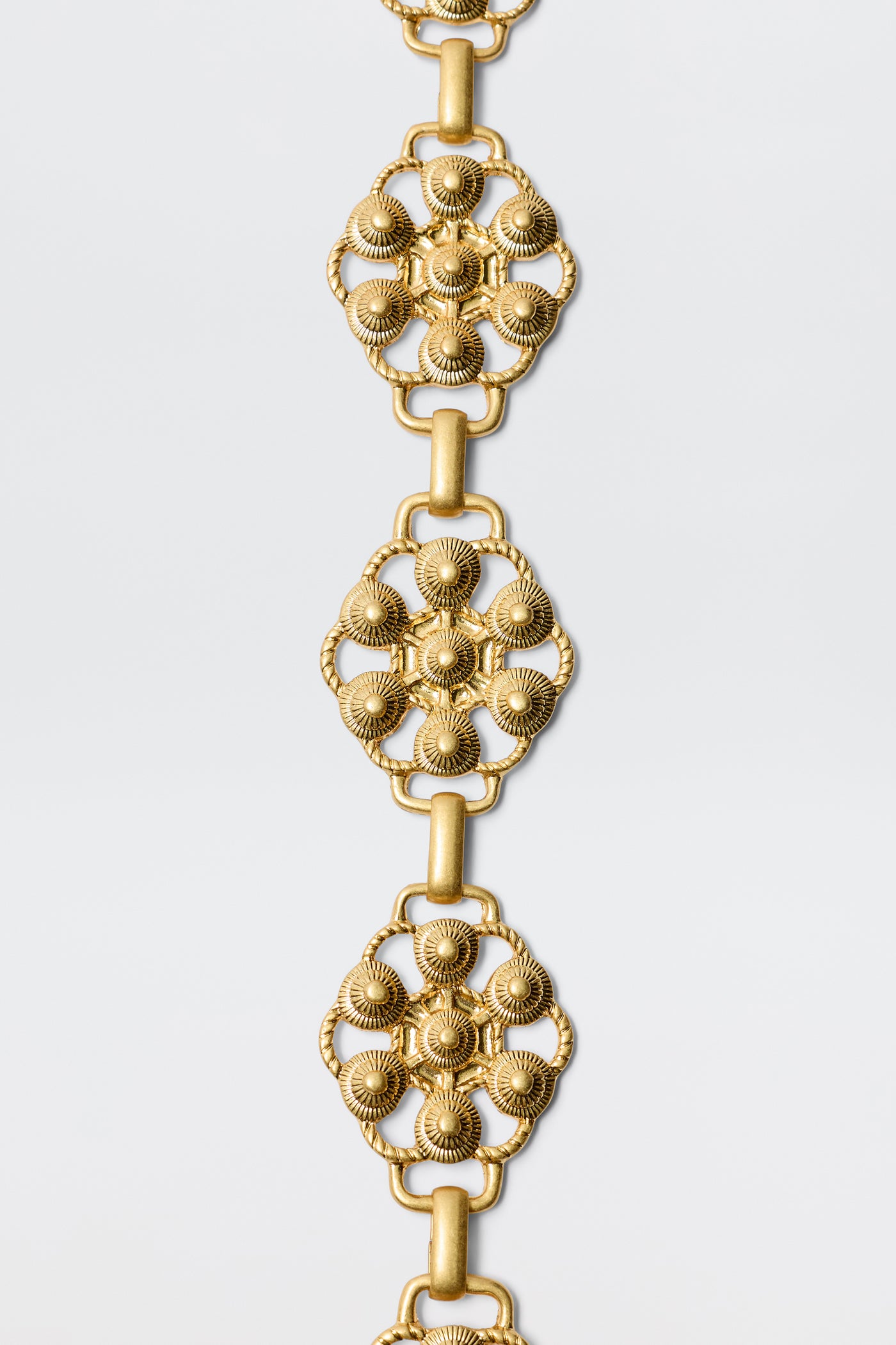 The Tiana - Gold bracelet features vintage-gold plating and a floral design inspired by RIXO’s signature daisy-chain belt.