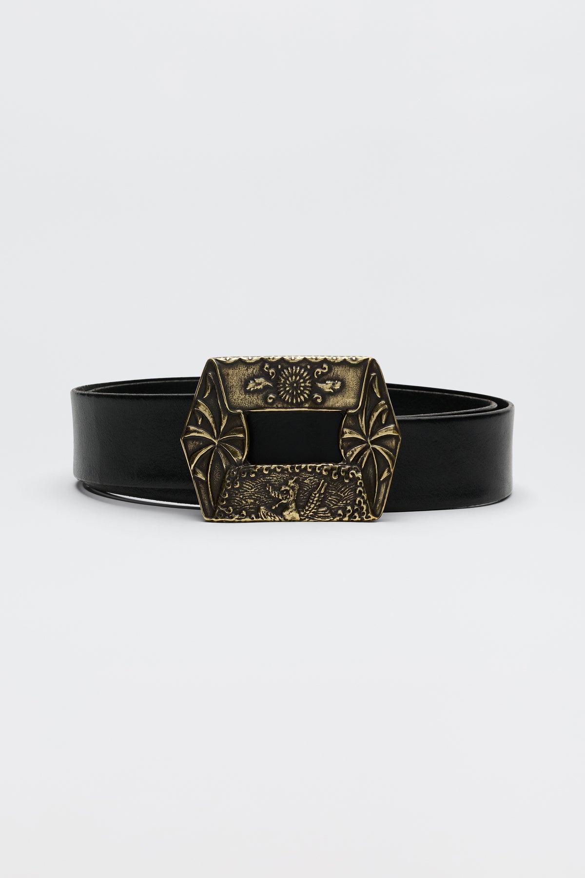 The Rhianna - Black is a black leather belt with a large, ornate brass buckle adorned with decorative engravings and geometric patterns, showcased against a plain white background.