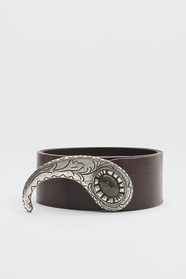The Daniella - Dark Brown is a leather belt with a large, ornate silver buckle featuring engraved details and a central dark green stone, shown against a plain white background.
