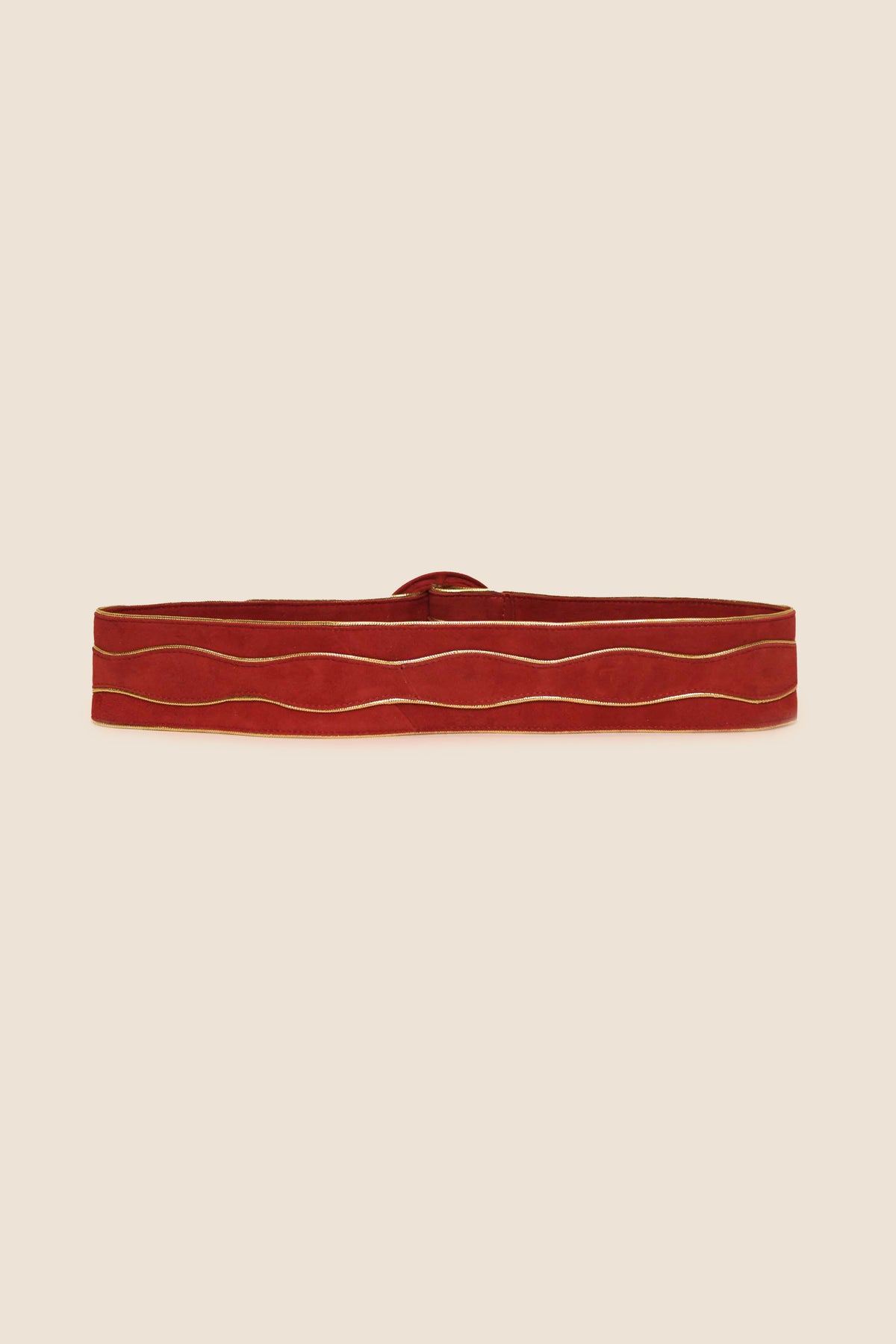 Introducing Catalina - Red: a striking suede belt distinguished by thin, wavy gold lines running horizontally along its length. This statement RIXO accessory, showcased against a beige background, features a unique wave-patterned design in bold red.