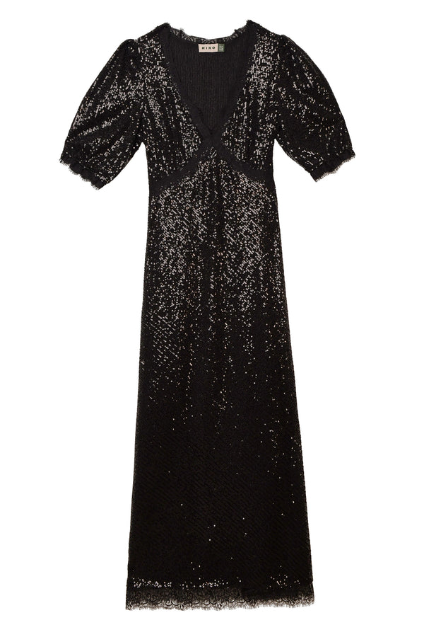Verena - Embellishment Black is a knee-length dress featuring a deep V-neckline, short slightly puffed sleeves, and a fitted waist. Its sparkly sequin texture gives this black dress an elegant and eye-catching look.