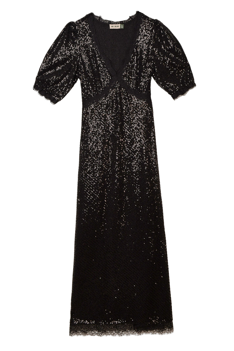 Verena - Embellishment Black is a knee-length dress featuring a deep V-neckline, short slightly puffed sleeves, and a fitted waist. Its sparkly sequin texture gives this black dress an elegant and eye-catching look.