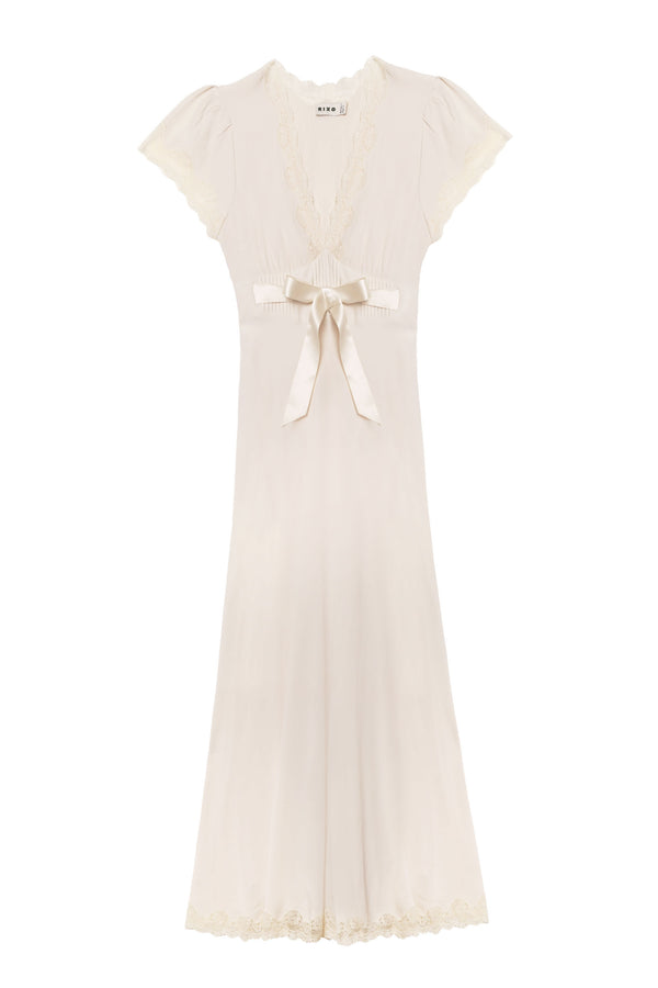 The Marlice - Pearl is an elegant, ivory vintage-inspired dress featuring short sleeves, lace trim on the neckline, sleeves and hem, a deep V-neck, and a satin bow waist for a timeless look.