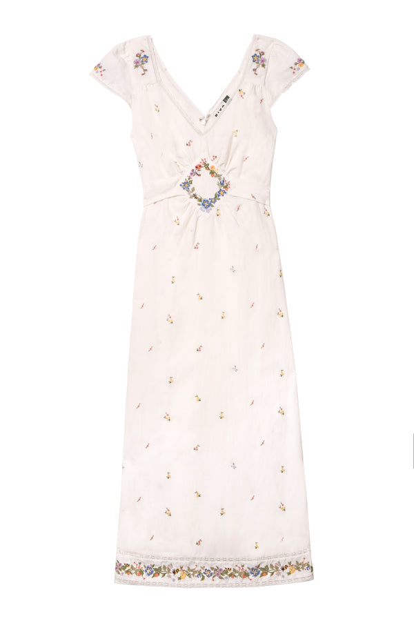The Carey - Meadow Embroidery Ivory is a light pink, short-sleeved midi summer dress in a linen blend, featuring vintage-inspired floral embroidery on the hem, a V-neckline, gathered waist, and delicate feminine details.
