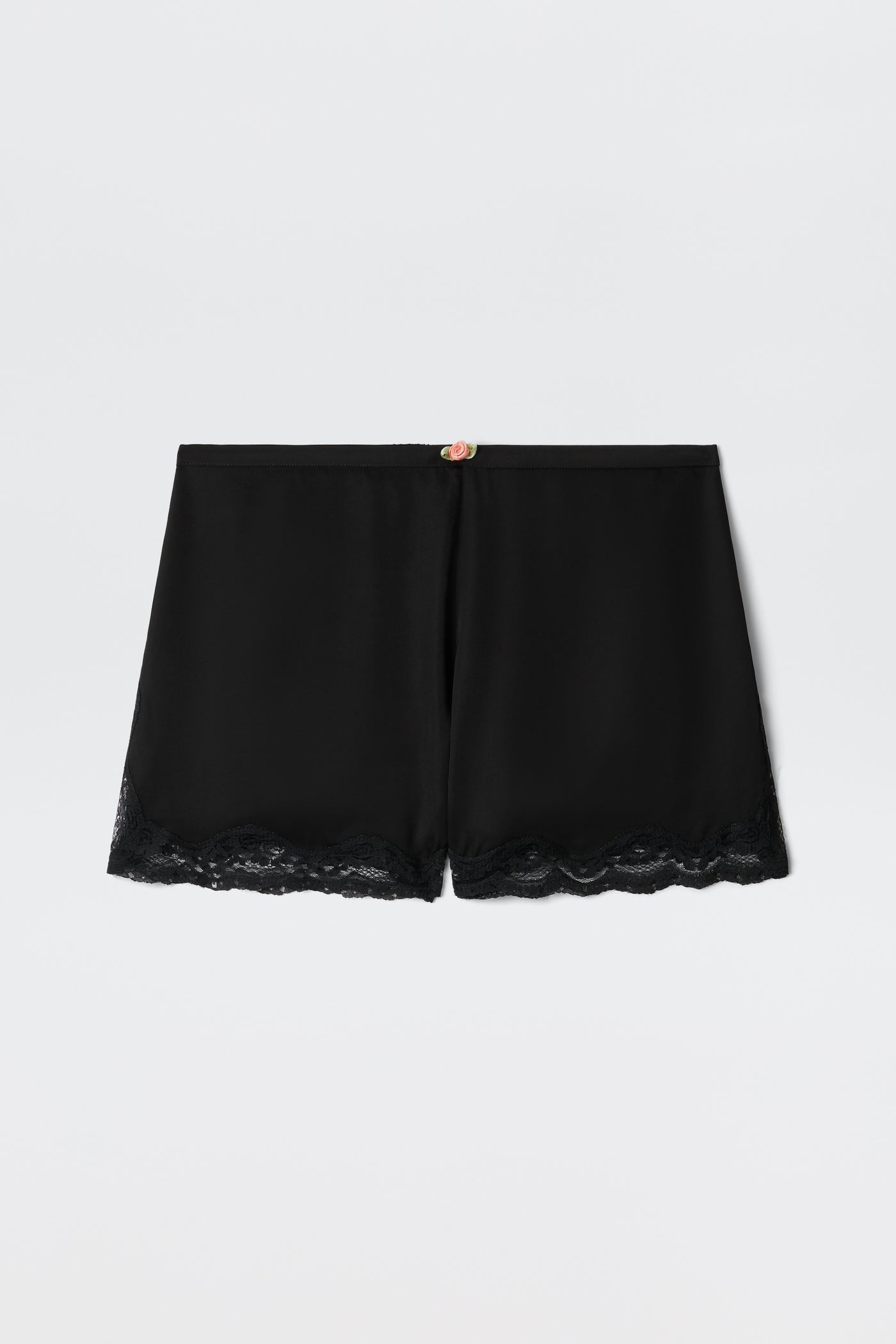 Lealia - Black satin shorts featuring a lace-trimmed hem and a delicate rose detail at the waistband, shown on a plain white background.