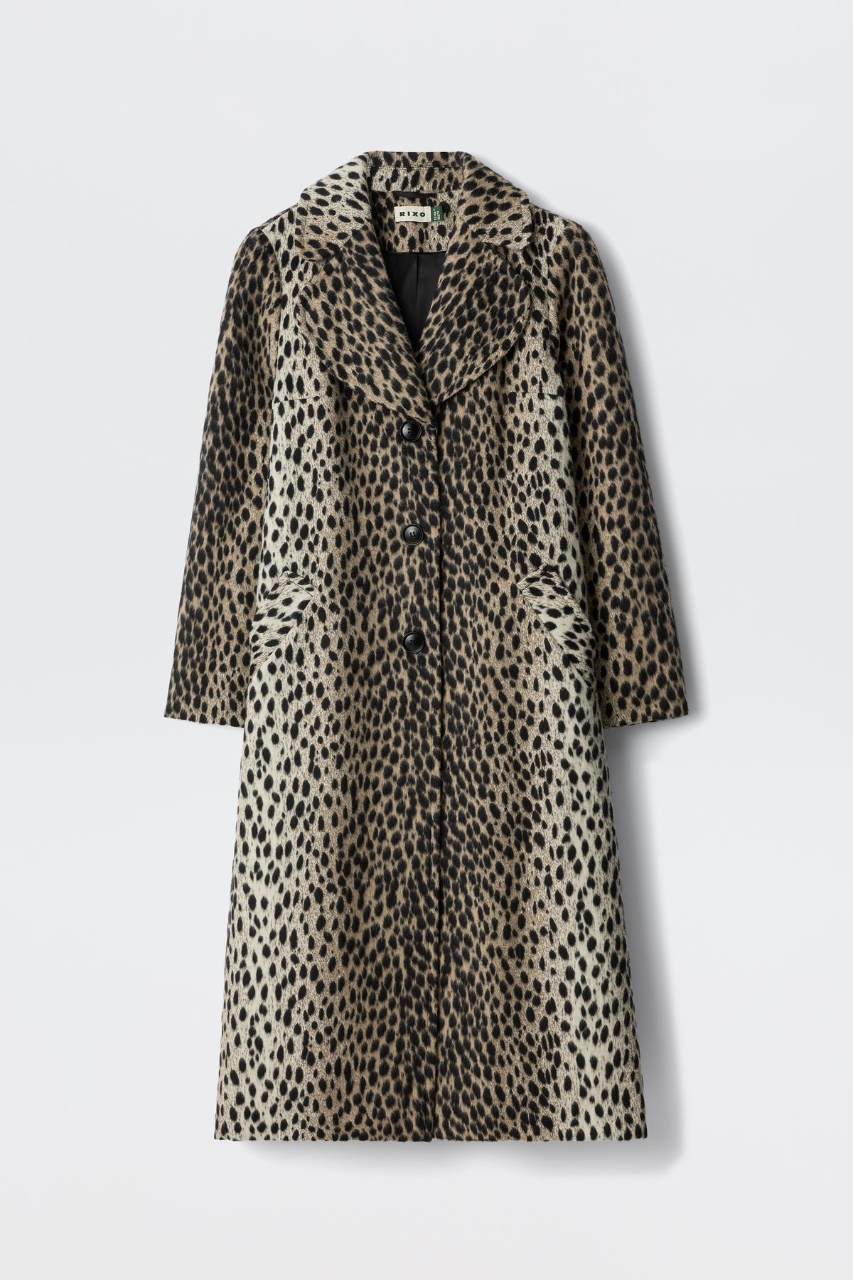 The Rosemary - Antelope Spot Jacquard Black is a long, knee-length coat with a spotted pattern, curved lapels, and three front buttons, shown against a plain white background.