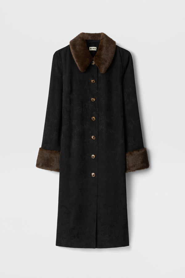 The Jonah - Black coat features a long black design with brown faux fur collar and cuffs, subtle textured pattern, and brown front buttons, shown against a plain white background.