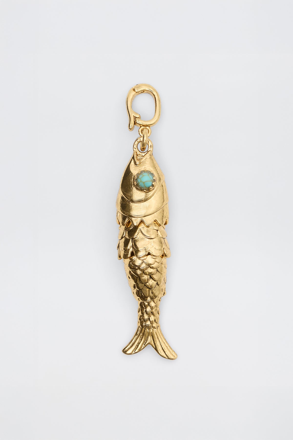 Nerissa - Gold: Fish-shaped pendant featuring detailed scales, a turquoise-colored eye stone, and a small top clasp for attaching to a chain, displayed on a plain white background.