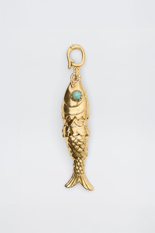 Nerissa - Gold: Fish-shaped pendant featuring detailed scales, a turquoise-colored eye stone, and a small top clasp for attaching to a chain, displayed on a plain white background.