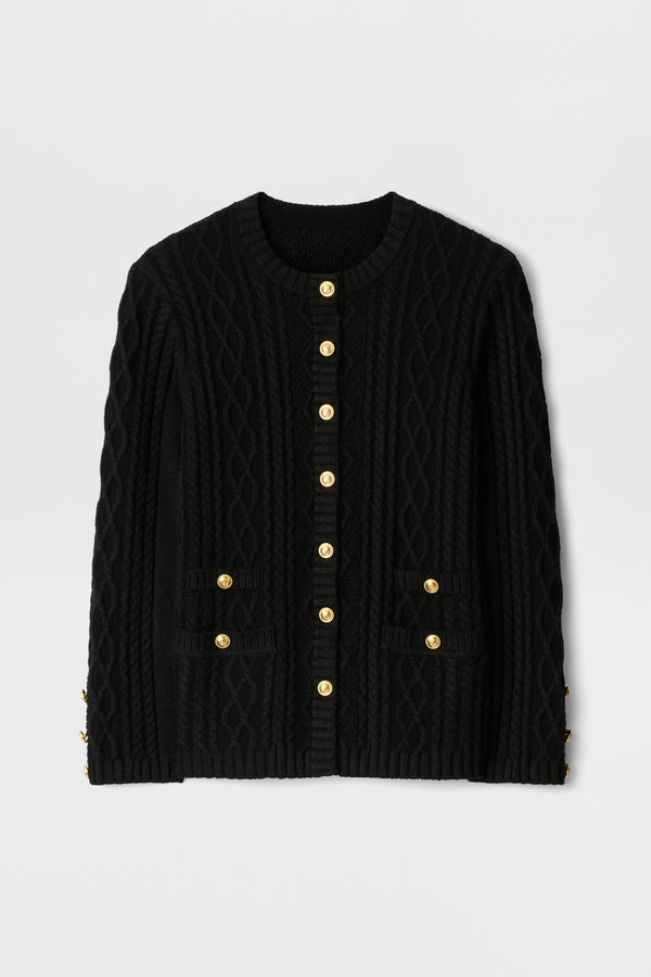 The Maurya - Black cable-knit cardigan features gold buttons down the front and on two front pockets, displayed flat against a plain white background.
