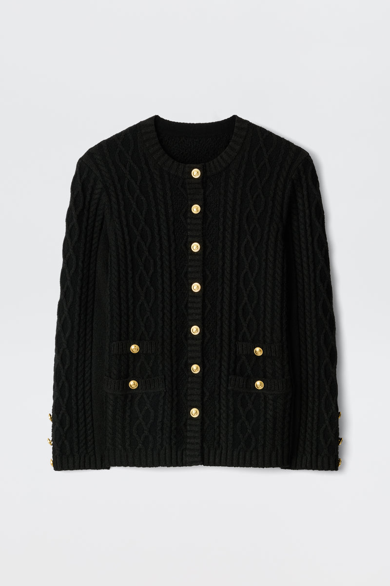 The Maurya - Black cable-knit cardigan features gold buttons down the front and on two front pockets, displayed flat against a plain white background.