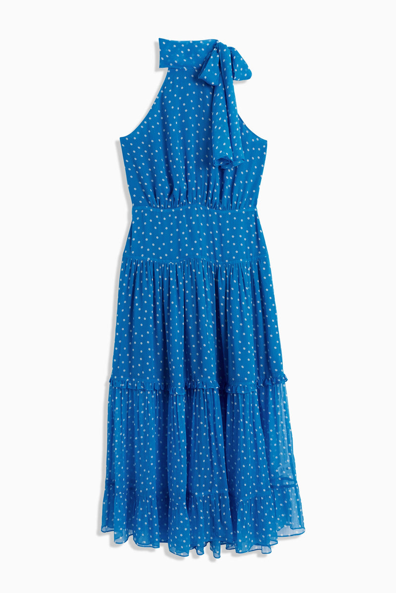Abi – Layla Dot Blue: Sleeveless blue georgette dress with white polka dots, high neckline with bow, fitted waist, and tiered flowy skirt. Ideal for special occasions or as a unique bridesmaid’s dress. Laid flat on white background.