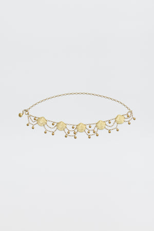 The Asia - Gold necklace is a delicate gold piece with small scallop shell charms and dangling beads symmetrically arranged on a fine chain, shown against a plain white background.