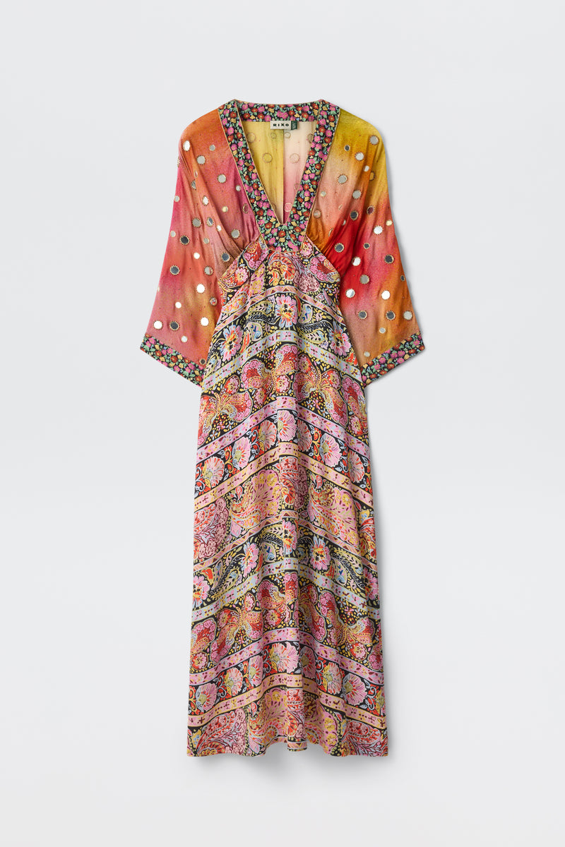 Introducing the Flori - Cara Swift Mix Multi: a vibrant, long-sleeve silk crepe de chine dress with a V-neckline, showcasing an artful blend of floral and paisley patterns in pink, orange, yellow, and white. The upper half is accented with white polka dots and intricate Shisha embroidery, while a multicolored border trim provides the perfect finishing touch.
