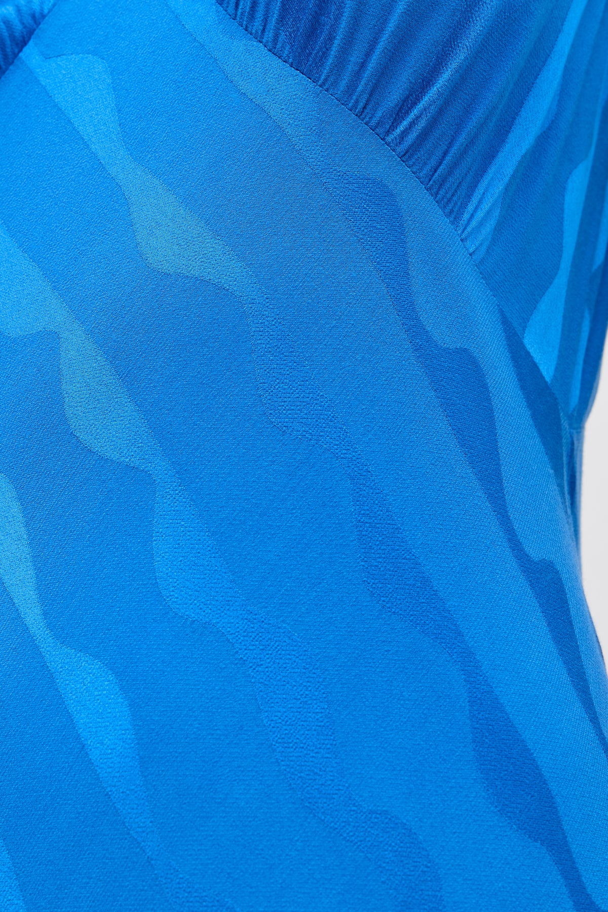 Close-up of the Sandrine - Wave Jacquard Blue, showcasing its wavy, textured blue patterns. The smooth, stretchy fabric is ideal for versatile styling and serves as a perfect transitional staple in any wardrobe.