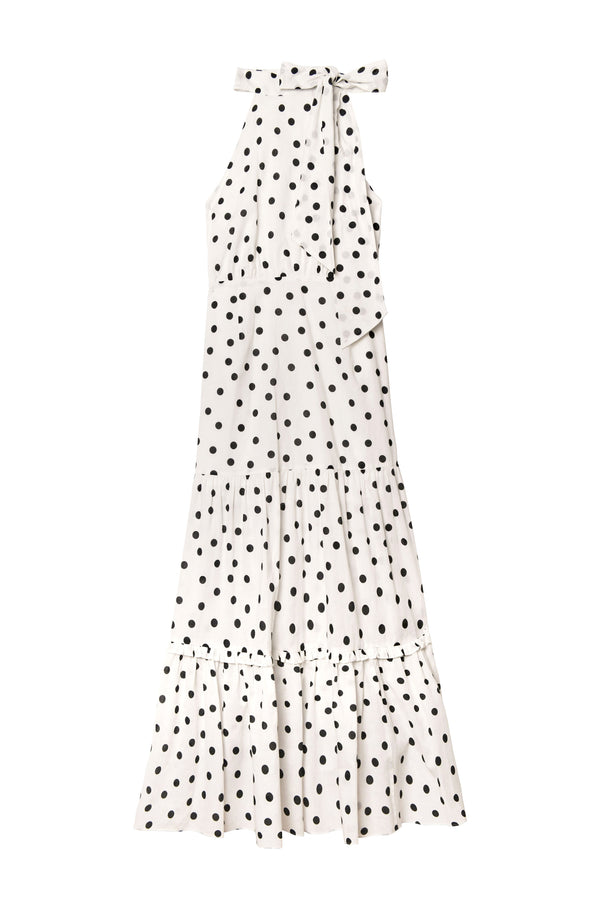 Perfect for summer, the Eleanor - Bohemia Spot Ivory dress features sleeveless cotton fabric, a white halter neckline, bow tie accent, and tiered flounced hem with polka dots.