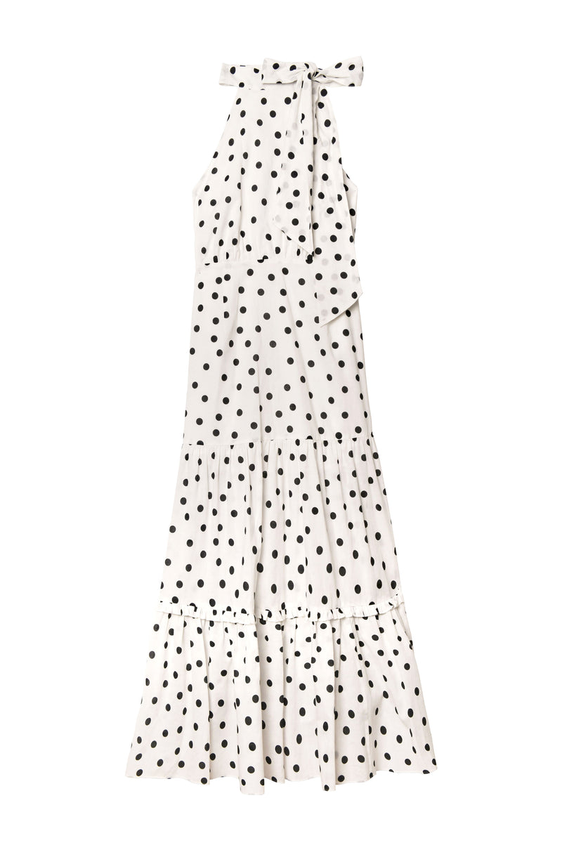 Perfect for summer, the Eleanor - Bohemia Spot Ivory dress features sleeveless cotton fabric, a white halter neckline, bow tie accent, and tiered flounced hem with polka dots.