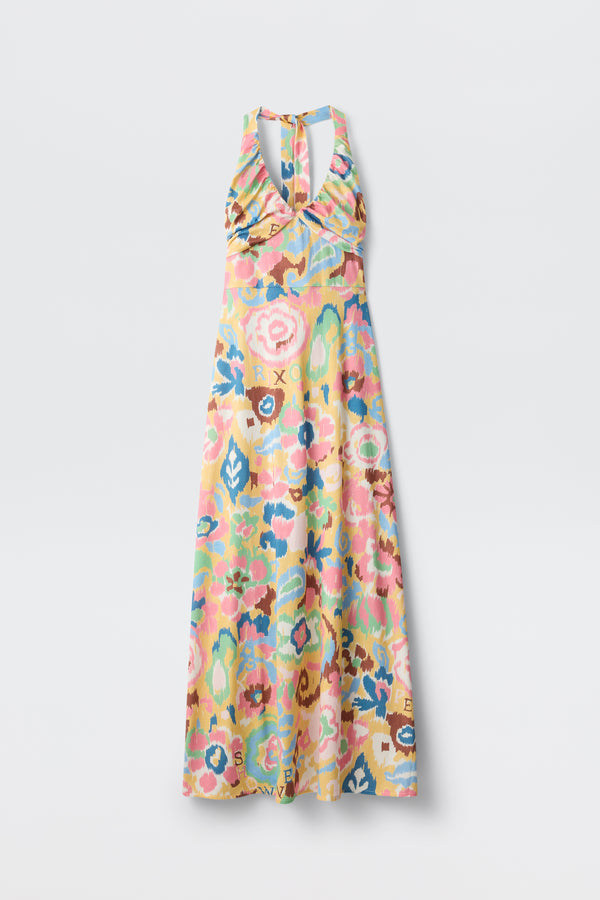 The Ilyana - Ikat Bloom Yellow is a sleeveless women’s halter maxi dress with a halter neckline and pastel multicolored floral pattern, shown against a plain white background.