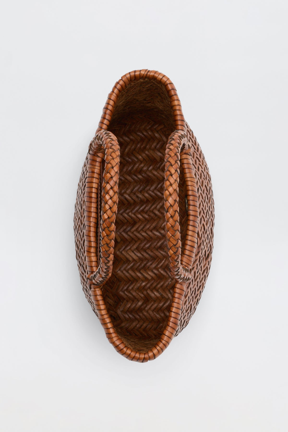 Lysia - Tan woven basket with two handles, viewed from above on a plain white background. Featuring a herringbone pattern and an oval shape, this basket is reminiscent of vintage woven bags.